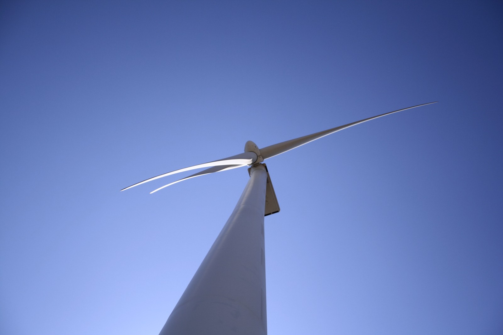 Wind turbine blade framed against a clear sky